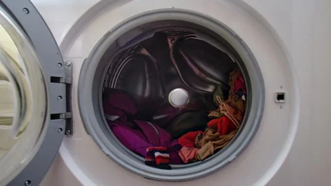 Loading clothes into the tumble dryer. Putting things in the dryer drum, stop Stock-Footage 345981381