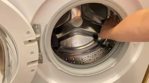 Loading clothes into washer for fresh clean Видео 343864450