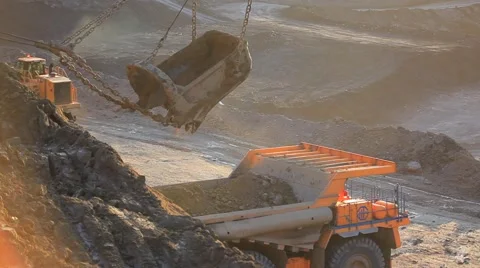 Loading coal into heavy dump truck at the opencast mining at sunset Stock Footage 61851073