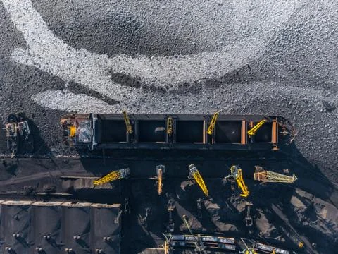 Loading coal mining in port on cargo tanker ship with crane bucket of train 스톡 사진
