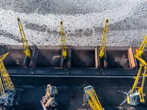 Loading coal mining in port on cargo tanker ship with crane bucket of train Stock Photos