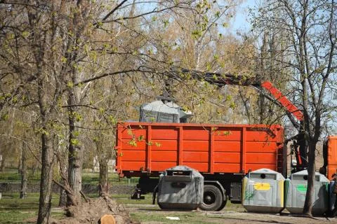 Loading of containers with household garbage onto a car. Hand manipulator for Foto stock