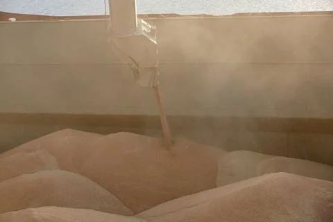 Loading corn onto a bulk carrier ship in the port at the grain terminal. Port Stock Photos