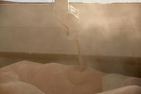 Loading corn onto a bulk carrier ship in the port at the grain terminal. Port Stock Photos