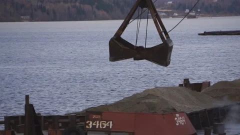 The loading crane discharges crushed stone from the barge to the pier Stock Footage 86053567