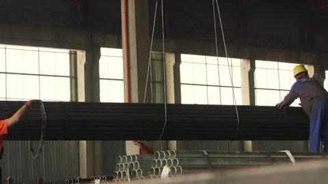 Loading by crane hook stacks of steel metal tubes in the warehouse Stock-Footage 120821809