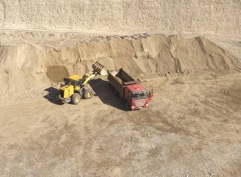 Loading crushed stone in a quarry into a dump truck Stock Photos