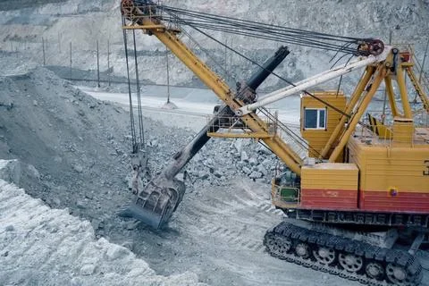 Loading of crushed stone into trolleys using an excavator. Stock Photos