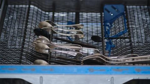 Loading dirty dishes into the dishwasher, stop motion. Filling the dishwasher Fotos de archivo