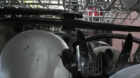 Loading dirty dishes inside dishwasher and closing door from interior point.. Stock Footage 318657423
