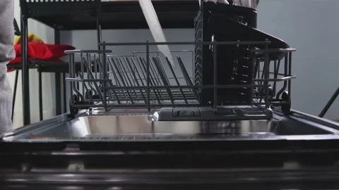 Loading dishes into the dishwasher. Stock Footage 138139061