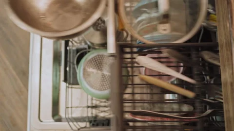 Loading dishes into the dishwasher at home in the kitchen Stock Footage 298890111