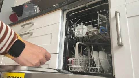 Loading the dishwasher and starting it Stock Footage 206363528