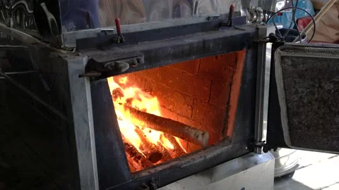 Loading firewood into maple syrup firebox arch.  Evaporator. 스톡 동영상 237815828