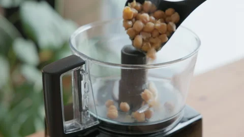 Loading Freshly Cooked Garbanzo Beans into a Food Processor for Hummus Prep 스톡 동영상 326642010
