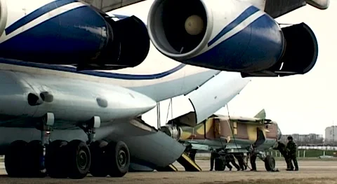 Loading fuselage of MiG-23 fighter into cargo compartment of Il-76 aircraft. Stock Footage 142008403
