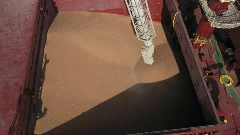 Loading grain onto a cargo ship for sea transport using a conveyor loader Stock Footage 157637058