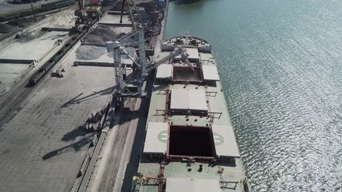 Loading grain onto a cargo ship for transportation by sea by a conveyor belt mac Stock Footage 155795263