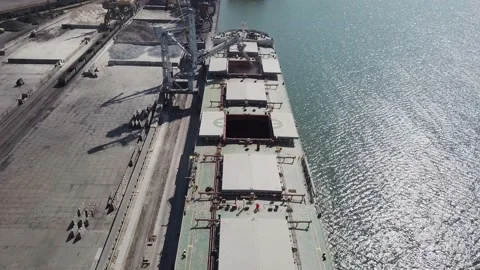 Loading grain onto a cargo ship for transportation by sea by a conveyor belt mac Stock Footage 155795556