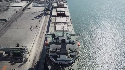 Loading grain onto a cargo ship for transportation by sea by a conveyor belt mac Stock Footage 155795797
