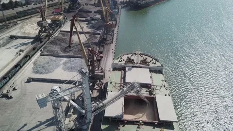 Loading grain onto a cargo ship for transportation by sea by a conveyor belt mac Stock Footage 155797106