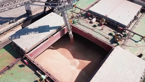 Loading grain onto a cargo ship for transportation by sea by a conveyor belt mac Stock Footage 155799919