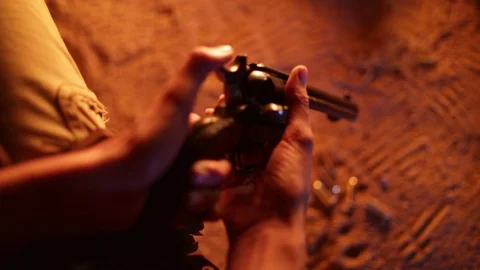 Loading gun by campfire old wild west cowboy outlaw single action army 45 Stock Footage 101357668