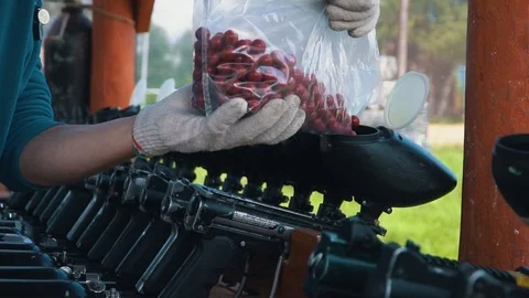Loading the gun colored balls for paintball games Stock Footage 118360178