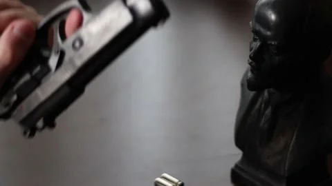 Loading Gun with Lenin Trinket. Russian Man Goes to War Stock Footage 219634529
