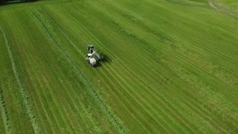 Loading hay with a combine into a tractor trailer Stock Footage 218345805