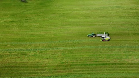 Loading hay with a combine into a tractor trailer Stock Footage 218345854