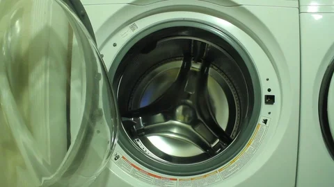 Loading laundry into a high-efficiency front-loader washing machine Vídeo Stock 92482885