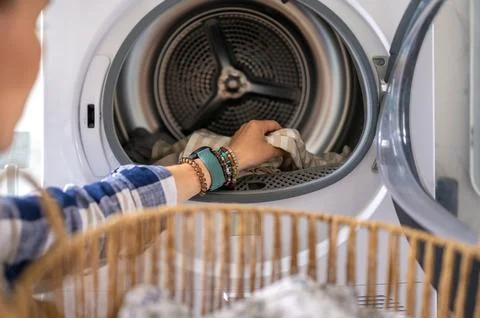 Loading laundry into modern clothes dryer Stock Photos