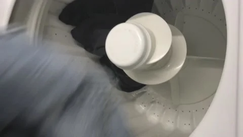 Loading Laundry into a top loading Washing Machine Stock Footage 141164358