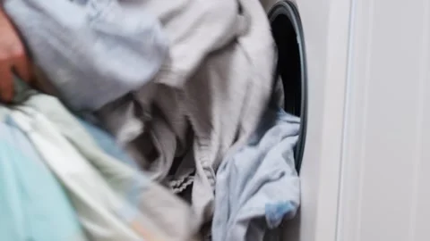 Loading laundry into the washing machine with simple steps Stockbeeldmateriaal 332268845