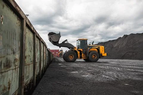 Loading of an loader into railway wagons. Excavator loading coal into wagons Stock Photos