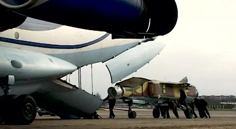Loading of MiG-23 fighter into cargo compartment of Il-76 transport aircraft. Stock Footage 143253835