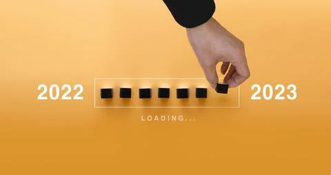 Loading new year 2022 to 2023 with hand putting wood cube in progress bar. .. Stock Photos