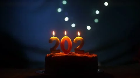 Loading new year 2022 with hand putting and burning candle on the party cake Stock Footage 163867008
