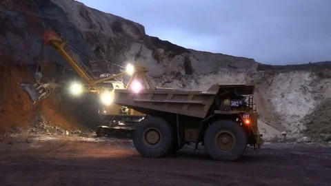 Loading the ore into heavy dump truck at the opencast mining site Stock Footage 83252333