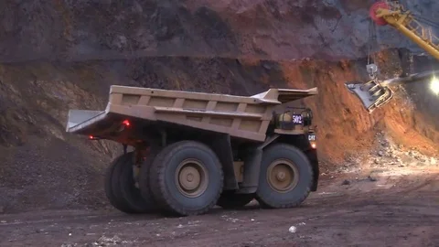 Loading the ore into heavy dump truck at the opencast mining site Stock Footage 83252355