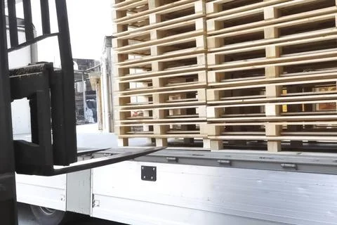 Loading pallets with forklift in stacks for storage or transportation Stock Photos