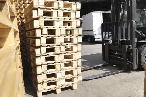 Loading pallets with forklift in stacks for storage or transportation Stock Photos