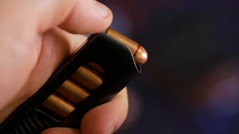 Loading pistol cartridge with bullets. Close Up. Stock Footage 89671341