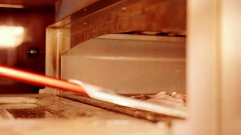 Loading pizza into the oven Stock Footage 158403674