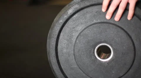 Loading Plate on Barbell (Closeup) Stock Footage