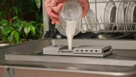 Loading the powder into dishwasher. A man pours powder in the dishwasher to wash Stock Footage 244637910