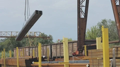 Loading of a profile pipe by a gantry crane into a freight car, loads metal in a Stock Footage 95168999