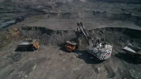 Loading queue from giant dump trucks to mining excavator. Open pit coal mining Stock Footage 203918459