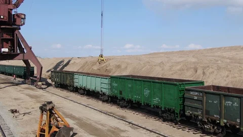 Loading sand into rail cars with the help of a career excavator Stock Footage 129799764